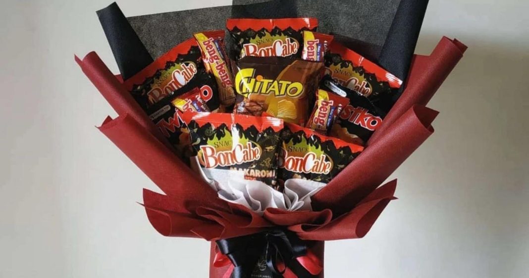 Tangan Menarik Pita Merah Pada Hadiah Yang Dibungkus Kertas Coklat